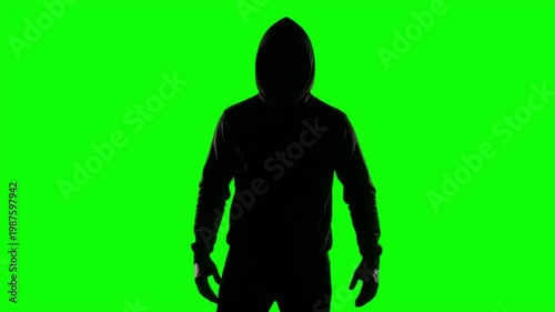 Mysterious Silhouette of a Man in a Hoodie Clenching Fists and Shaking on a Green Screen Background