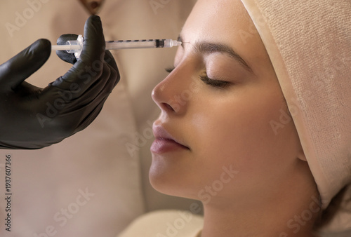 Hands of cosmetologist making injection in face, lips. Young woman gets beauty facial injections in salon. Face aging, rejuvenation and hydration procedures. Close up. Selective focus.