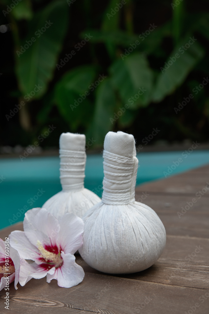 custom made wallpaper toronto digitalSet of  thai herbal heat bag for asian thai massage with flowers on wooden background front of the pool. Recreation and health care concept.  Selective focus.
