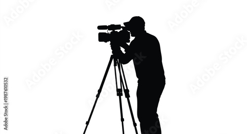 Filmmaker operating a camera on a tripod a striking silhouette