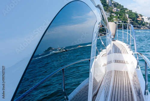 Luxury yacht cruising on blue ocean with island view and reflection