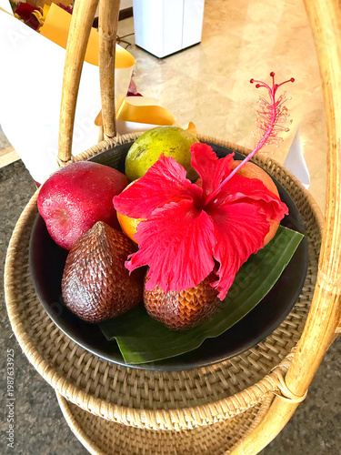 Fruit basket with Snake Fruit or Salak and a pretty tropical hibiscus flower