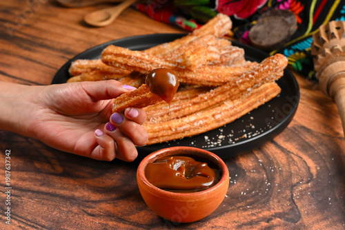 Close up of tasty churro with sugar and caramel dip, food photography