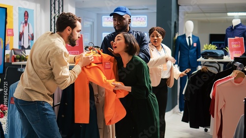 Obraz na plátně Fight between two angry shoppers on black friday, trying to buy clothes with red price tags for half price payment in clothing store