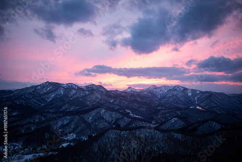 Snowy mountain range under vibrant pink sunset sky