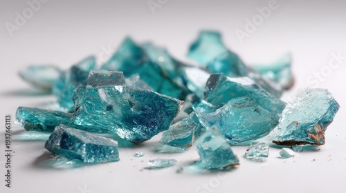 A collection of irregular glass shards, broken and scattered on a white background, each piece gleaming in the light, creating an intriguing visual texture