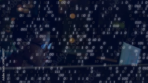 Woman analyzing data at night desk, monitor output starting streaming binary digits, obscuring view