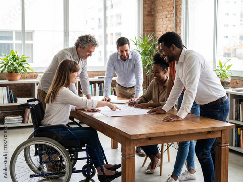 Diverse team having planning meeting with woman in wheelchair