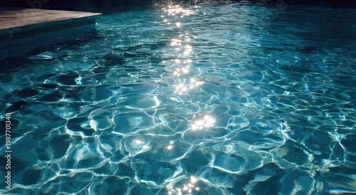Bright sunlit ripples dance on a cool, clear swimming pool surface