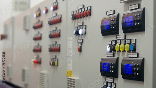 Industrial control panel with digital displays and push buttons in a manufacturing plant