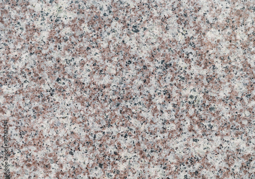 Polished granite stone surface with natural red and black speckles