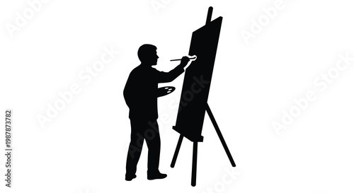 Silhouette of an artist painting at an easel in a studio