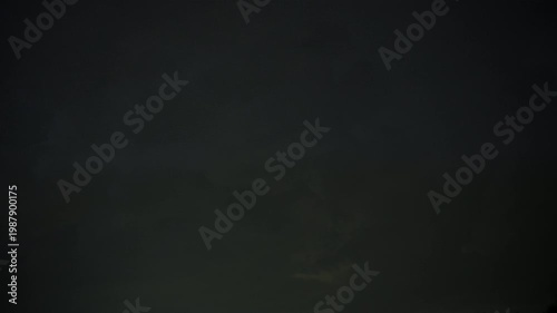Dark storm clouds with lightning in night sky. Dramatic thunderstorm, heavy weather, atmospheric nature background.