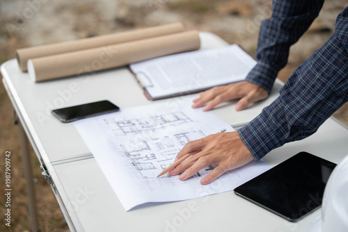 Foto Architect checking blueprint on working table at construction site