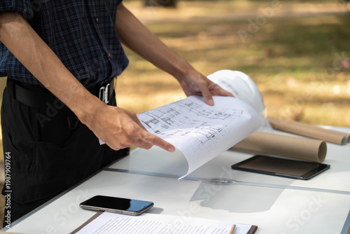 Konstfotografi Architect holding blueprint above working table at construction site