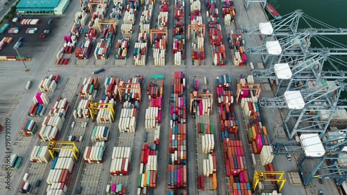Aerial Top view of a large cargo ship loading and unloading containers at a deep-sea port. This aerial scene highlights global logistics, international trade, and maritime transportation hubs.