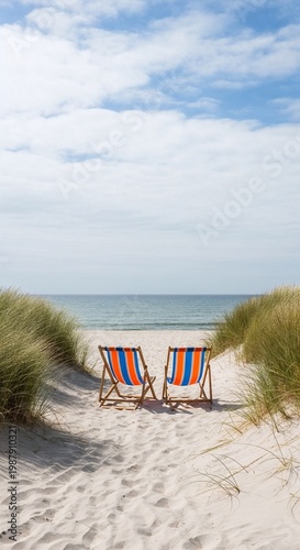 Empty beach chairs on sandy path to sea