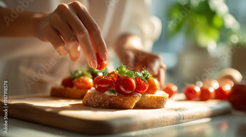 Expert hands adding ripe cherry tomatoes to freshly prepared bruschetta.