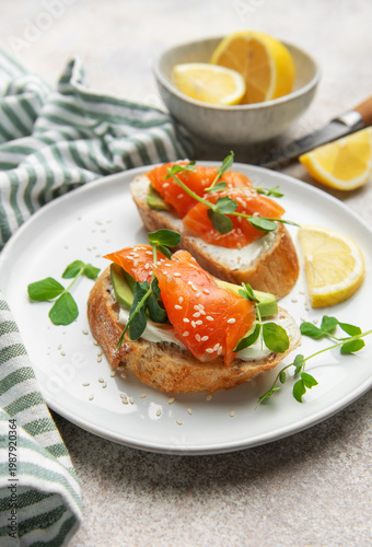 Salmon avocado toasts with microgreens and lemon
