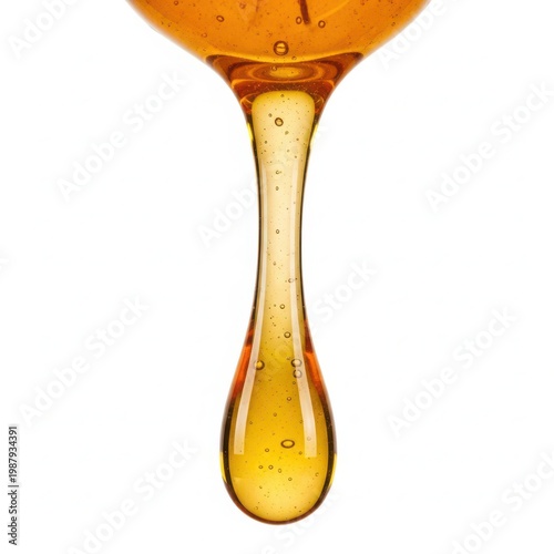 Close-up view of a glass filled with golden liquid and a dripping droplet.