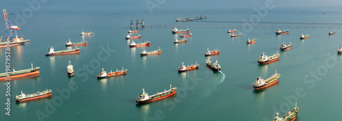 Aerial view of numerous oil and gas tankers anchored in a bay, showcasing large-scale maritime energy transport and dense commercial sea traffic.