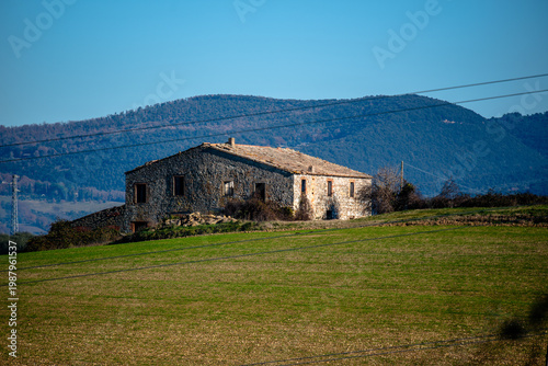 Stone farmhouse on green hills in rural Italy