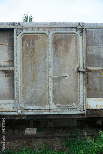 Old weathered train bogy cargo container with rust and scratches, showing aged metal textures and industrial details, perfect for concepts of history, transportation, and decay.