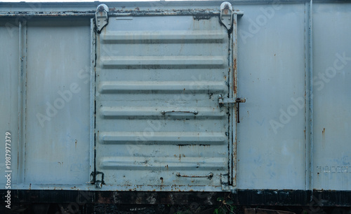 Old weathered train bogy cargo container with rust and scratches, showing aged metal textures and industrial details, perfect for concepts of history, transportation, and decay.
