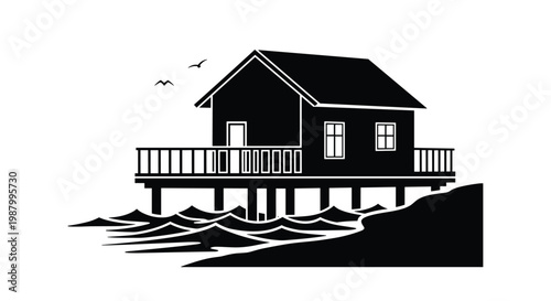 Beautiful beach house silhouette built on wooden stilts over the ocean waves with seagulls flying in the sky for a coastal theme.