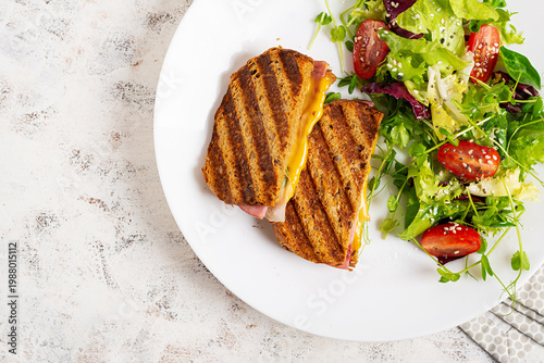 Canvas-taulu Healthy lunch with toasted sandwich and vegetable salad, top view