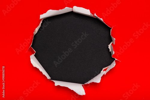 Fotografie Ripped Red Paper with Black Hole Revealing Inner Texture