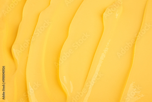 A sample texture of delicate yellow custard banana cream. Soft waves of creamy surface fruit banana cream for pastry baking. Top view. A copy space.