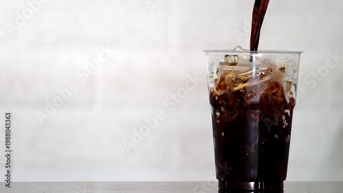 4K Close-up of iced coffee mixed with milk creating beautiful swirl texture Refreshing beverage, Concept ideal for cafe drink menu.