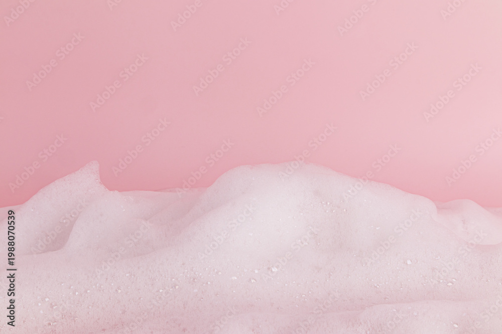 Fototapeta premium Chic white fluffy foam, soap foam texture, shampoo on a pink background. Layout for advertising detergents, spa cosmetics. Front view. A copy space