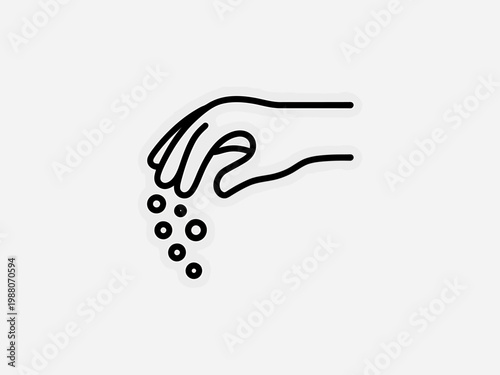 Hand sprinkling small round objects downwards