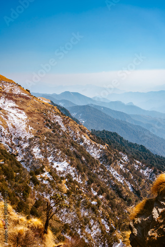 Canvas Print A serene mountain landscape with snow and trees under a clear blue sky in Tungna