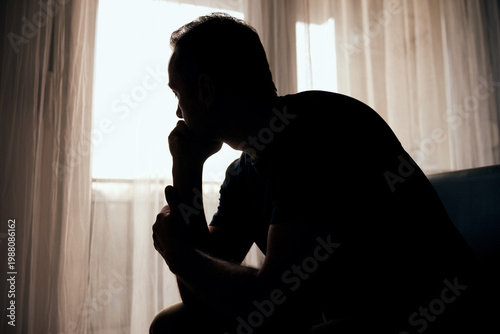 Tableau sur toile Silhouette of depressed, sad and lonely man in the apartment.