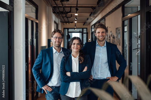 Confident business team standing together in modern office corridor