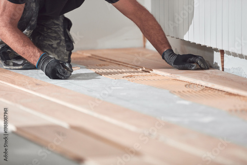 Schilderij op canvas Professional handyman installing laminate flooring in a new apartment