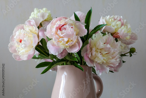 bouquet of soft pink peonies in ceramic jug on neutral background elegant floral arrangement home decor