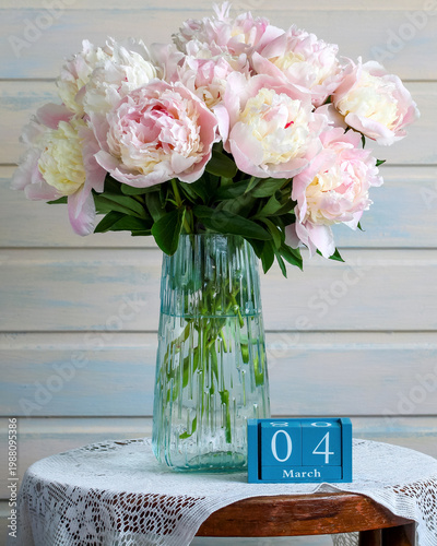 March 4. calendar and bouquet of light garden peonies in a vase. spring holiday event or birthday.