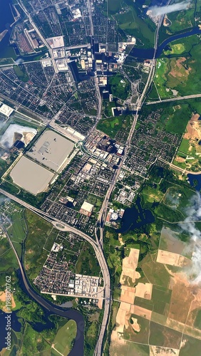 Aerial view of a city with roads, buildings, and green spaces