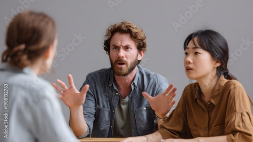 Three individuals engage in an animated conversation around a table