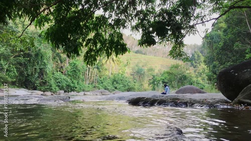 Serene waterfall and forest stream promoting eco tourism, lush nature escape and sustainable travel.