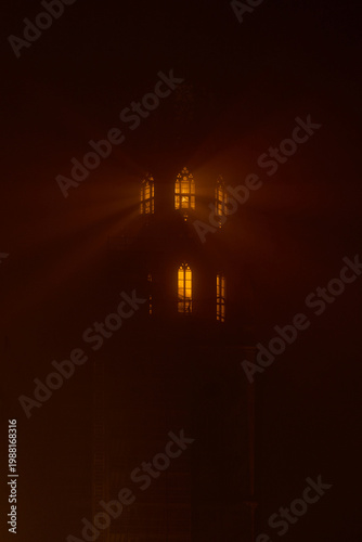Foto Warm light shining through tower windows in dense fog creates dramatic glowing rays and mysterious atmosphere