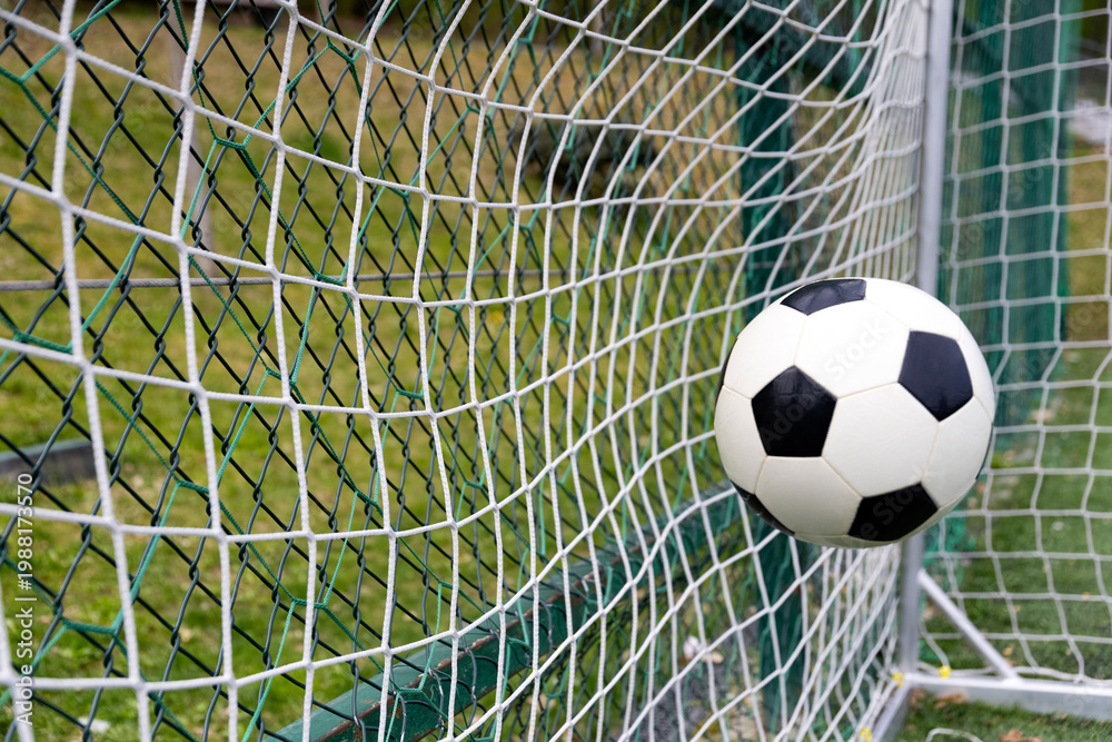 Naklejka premium Soccer ball on goal with net background