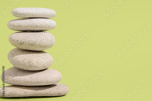 Canvas Print Balanced stack of smooth zen stones on pastel green background with copy space,