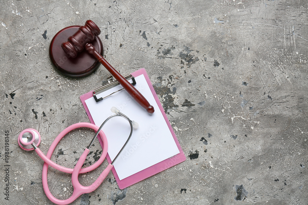 Obraz premium Judge gavel, clipboard and stethoscope on grey grunge background. Concept of health care reform