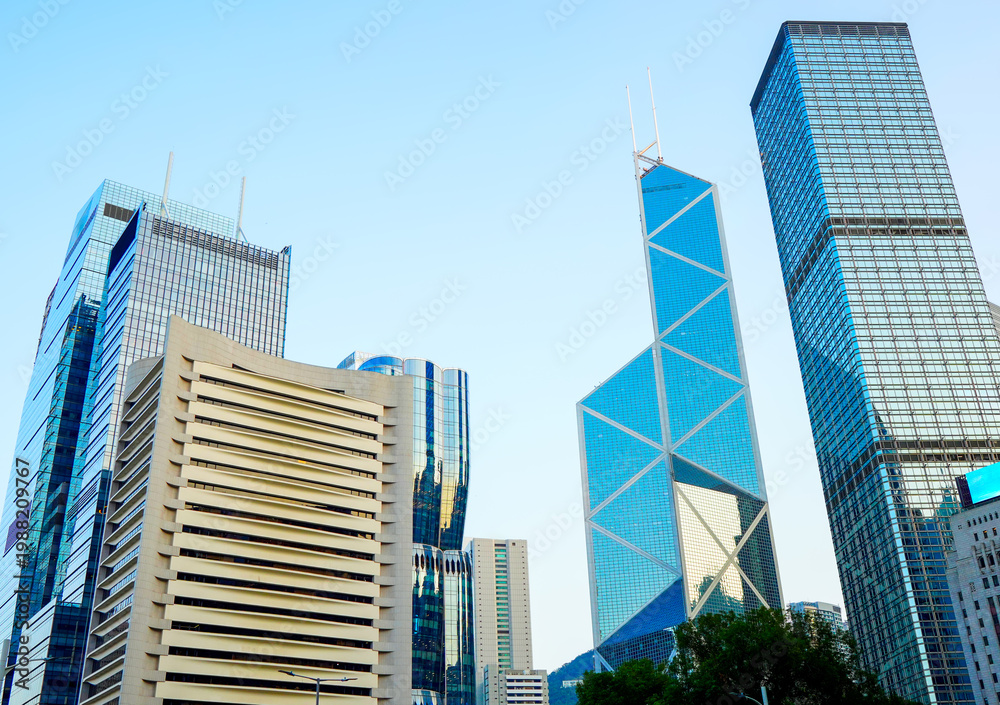Fototapeta premium Glass skyscrapers in financial district of Hong Kong. Glass building in of Hong Kong's major financial district. Ultra-modern glass tower. Glass windows skyscrapers. Futuristic architecture. 