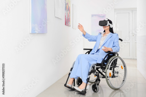 Young woman in wheelchair with controller and VR glasses visiting art gallery